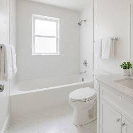 Modern bathroom with white fixtures, sink, and mirror.