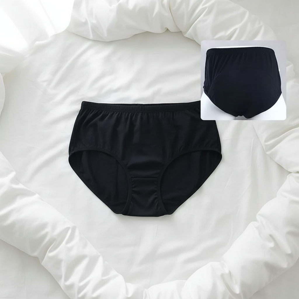 Solid Black High Absorption Briefs flat lay on white bedding